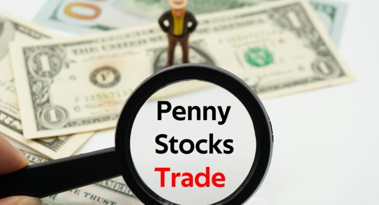 Magnifying glass over dollar bills reading Penny Stocks Trade